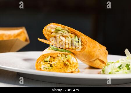 Tortillas roulent avec du curry de poulet et des légumes sur la plaque blanche. Burrito de poulet. Des aliments sains. Banque D'Images