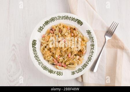 Halusky de Kapustove connu sous le nom de Strapacky, plat classique en Slovaquie, boulettes de pommes de terre bouillies au chou aigre et à l'oignon, surmontées de bacon frit et frais Banque D'Images