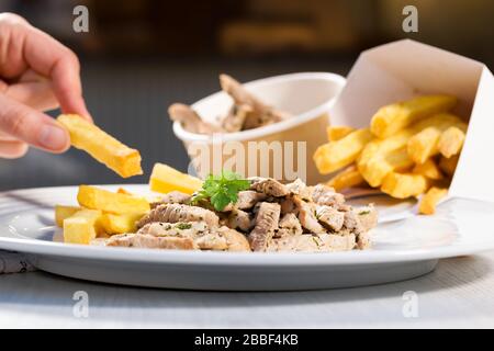 Bifteck rayé avec pesto et pommettes sur la plaque blanche. Cuisine gastronomique de rue. Banque D'Images