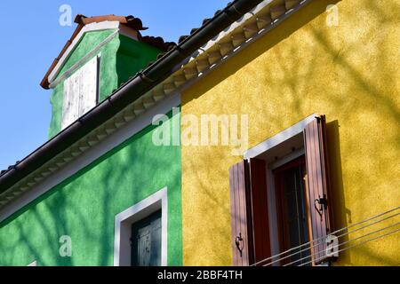 Venise, Italie-février 2020; vue rapprochée d'une section de l'un des vieux bâtiments de Burano près de Venise avec façade colorée en vert et jaune Banque D'Images