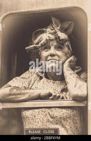 Sépia gros plan de 1940 femme/ femme au foyer de guerre, isolé à la fenêtre de la voiture de train à vapeur d'époque, Severn Valley Heritage Railway, 1940s événement, Royaume-Uni. Banque D'Images