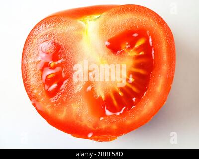 Une demi-tomate rouge mûre sur fond blanc Banque D'Images