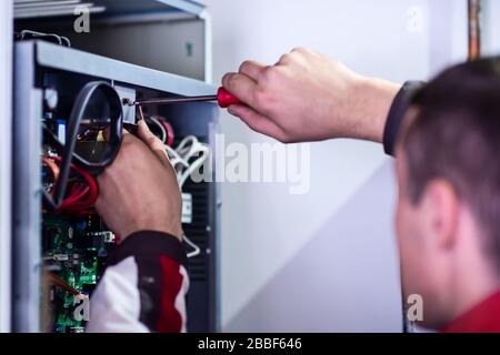 Gros plan de l'ingénieur électricien travaillant avec les câbles électriques de la boîte à fusibles moderne. Équipement électrique de réglage du nouveau câblage de tension Banque D'Images