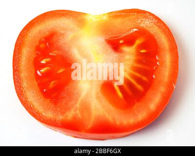 Une tranche de tomate rouge mûre sur fond blanc Banque D'Images