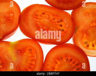 Tranches de tomates rouges mûres sur fond blanc Banque D'Images