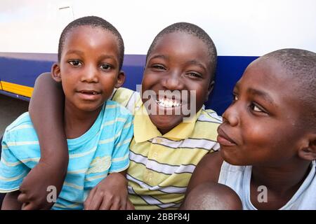 Soweto, Afrique du Sud - 11 septembre 2009: Trois jeunes garçons africains qui font preuve d'amitié et de joie dans un canton de Soweto Banque D'Images