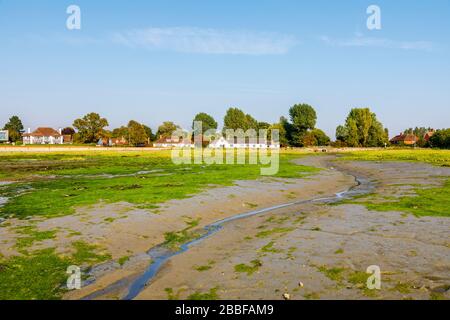 Vue sur les bâtiments de Shore Road sur des appartements de boue à marée basse, Bosham, un village côtier sur Chichester Harbour, West Sussex, sud de l'Angleterre Banque D'Images