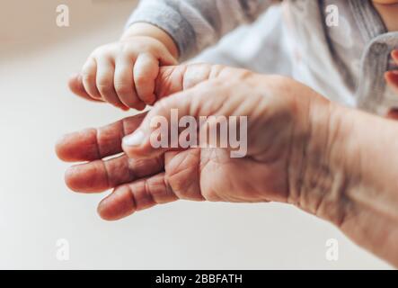 Une vieille femme et un enfant tenant les mains ensemble Banque D'Images