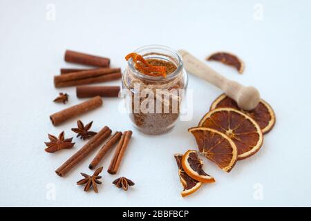 Bâtonnets de cannelle, oranges séchées et anis étoilé avec bouteille de sucre brun avec peu de profondeur de champ sur fond blanc. Cuisson des ingrédients Banque D'Images