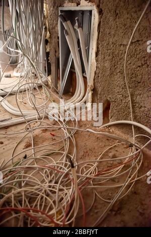 Prises avec câbles dans un mur. Arrière-plan du câblage. Les fils électriques s'y coincent du trou des prises électriques sur le mur. Nouveau câblage électrique Banque D'Images