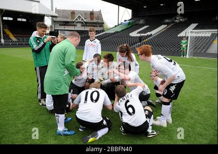 Les enfants célèbrent après avoir joué au football sur le terrain avant le Charity All Star Match Banque D'Images