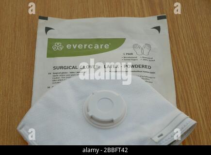 Masque FFP2 visage coronavirus covid-19 santé médicale sur le nez de bouche et gants chirurgie poudre stérile latex paire. Protection contre le virus de la pollution Banque D'Images