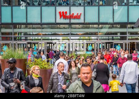 Une journée d'été très animée au Westfield Shopping Mall dans East London Shoppers remplir l'une des entrées du centre avec la marque au-dessus des portes. Banque D'Images