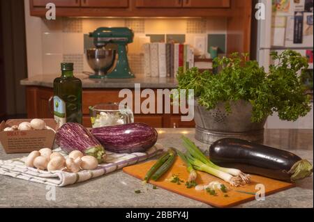 Aubergines, champignons, échalotes, huile et espaces sur le comptoir de cuisine. Préparation de la nourriture pour faire baba ganoush. Banque D'Images