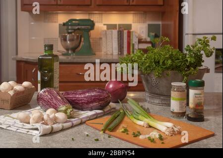 Aubergines, champignons, échalotes, huile et espaces sur le comptoir de cuisine. Préparation de la nourriture pour faire baba ganoush. Banque D'Images