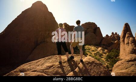 Un jeune couple heureux tenant les mains et regardant la vue tout en faisant de la randonnée ensemble à travers un paysage désertique Banque D'Images