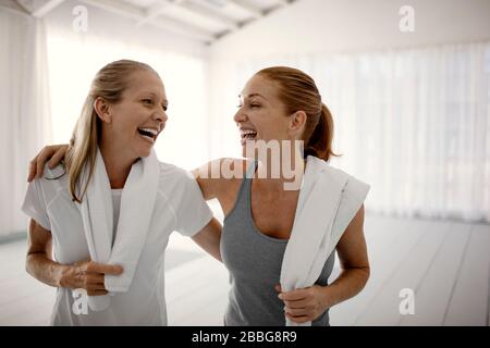 Les femmes souriantes rient après avoir pratiqué le yoga Banque D'Images