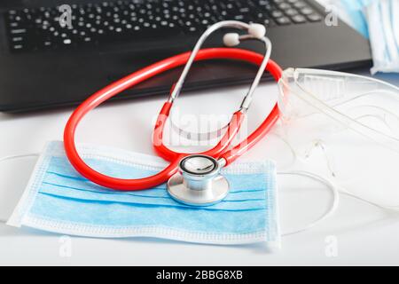 Rendez-vous avec un médecin. Thermomètre, stéthoscope rouge, lunettes de protection documents médicaux sur le lieu de travail des médecins au bureau de la clinique. Concept médecine soins de santé Banque D'Images