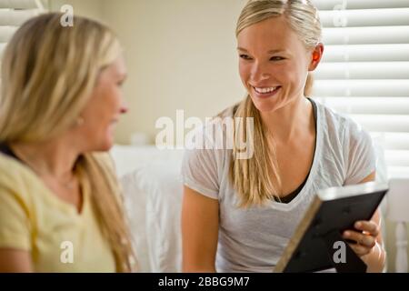 Jeune femme souriante montrant à son ami une photo dans un cadre photo Banque D'Images
