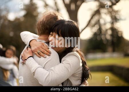Couple adulte moyen embrassant dans un parc Banque D'Images