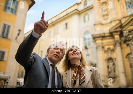 Homme d'affaires mûr montrant à un client les monuments historiques de la ville Banque D'Images