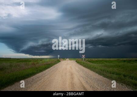 Tempête avec éclair clignotant à la fin d'une route rurale de gravier dans le sud du Manitoba Canada Banque D'Images