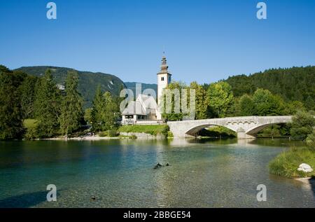 Lac Bohinj avec église de St.Jean le Baptiste en arrière-plan, Parc National Triglav, Slovénie Banque D'Images