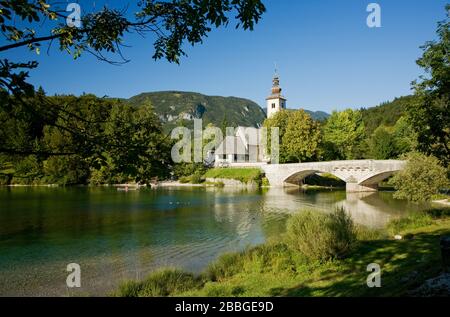 Lac Bohinj avec église de St.Jean le Baptiste en arrière-plan, Parc National Triglav, Slovénie Banque D'Images