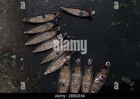 Dhaka, Bangladesh. 31 mars 2020. Un homme de bateau passe le bateau alors que d'autres hommes de bateau attendent les passagers pendant le maintien à l'échelle du pays pour empêcher la propagation des épidémies de coronavirus (COVID-19), à la rive de la rivière Buriganga. Crédit: MD Mehedi Hasan/ZUMA Wire/Alay Live News Banque D'Images