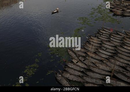 Dhaka, Bangladesh. 31 mars 2020. Un homme de bateau passe le bateau comme d'autres ancres de bateau sur les rives de la rivière Buriganga, pendant le maintien à l'échelle du pays pour empêcher la propagation des épidémies de coronavirus (COVID-19). Crédit: MD Mehedi Hasan/ZUMA Wire/Alay Live News Banque D'Images