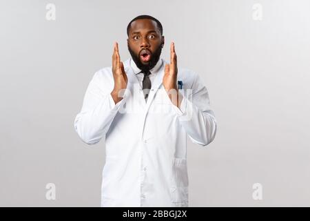 Portrait de jeune médecin masculin afro-américain choqué sans voix, médecin entendu laboratoire commence à tester le vaccin covid-19, se sentent étonnés et Banque D'Images