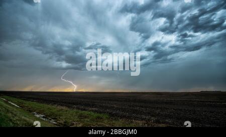 Tempête avec foudre frappant sur le terrain dans le sud rural du Manitoba Canada Banque D'Images