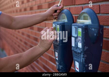 Gros plan de l'homme mettant de l'argent dans le parking Meter Banque D'Images