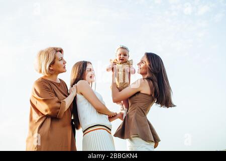 Trois générations. Grand-mère, filles et petite-fille sur un pré vert. Banque D'Images