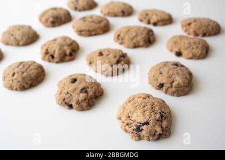 Biscuits au chocolat faits maison en rangées sur fond blanc Banque D'Images