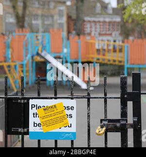 Un terrain de jeux pour enfants fermé et déserté dans le sud de Londres, au Royaume-Uni, lors de l'épidémie de virus Corona en 2020. Portes verrouillées, panneau d'avertissement sur la porte. Banque D'Images