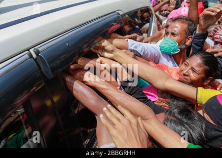 Dhaka, Bangladesh. 31 mars 2020. Les gens se précipitent sur les voitures pour obtenir une aide financière pendant le verrouillage national imposé comme mesure pour empêcher la propagation de COVID-19, à Dhaka, au Bangladesh, le 31 mars 2020. Un verrouillage national est en cours dans tout le pays pour freiner la propagation du roman COVID-19 à la suite de cinq décès et au moins 51 infections. Crédit: Suvra Kanti Das/ZUMA Wire/Alay Live News Banque D'Images