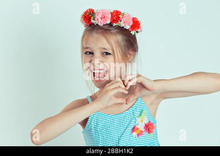 Gros euphorie hurlant joyeux jeune fille joyeux enfant faisant signe de coeur avec les mains. Sentiment d'expression d'émotion positive. Modèle caucasien enfant avec f Banque D'Images