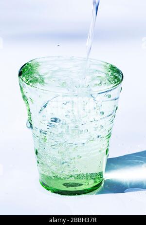 Verser de l'eau dans un verre Banque D'Images