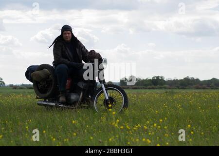 Un post apocalyptique homme sur moto dans pré Banque D'Images