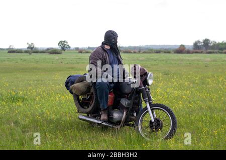 Un post apocalyptique homme sur moto dans pré Banque D'Images