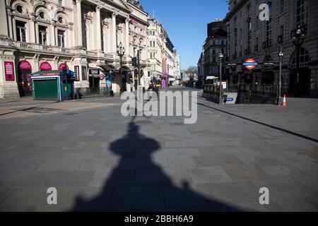 L'ombre de la statue d'Eros à Piccadilly Circus a presque déserté en raison de l'épidémie de Covid-19 et de la distanciation sociale sur ce qui serait normalement une journée animée et animée avec des hardes de gens dehors pour faire des achats et socialiser le 22 mars 2020 à Londres, Angleterre, Royaume-Uni. Le coronavirus ou le Covid-19 est une nouvelle maladie respiratoire qui n'a pas été observée auparavant chez l'homme. Bien qu'une grande partie ou l'Europe ait été mise en place dans le cadre de leur stratégie à long terme, le gouvernement britannique a annoncé des règles plus strictes, et en particulier des distances sociales. Banque D'Images