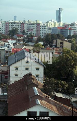 Vue sur le vieux quartier de Bucarest, Roumanie, avec des usines abandonnées en premier plan et des immeubles d'appartements communistes dans le dos Banque D'Images