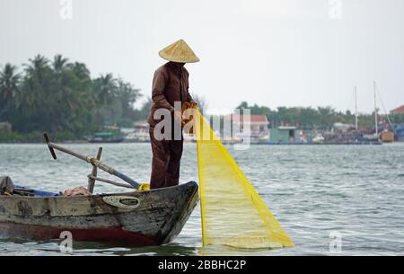 pêcheur vietnamien sur petit bateau de pêche avec filet de poisson Banque D'Images