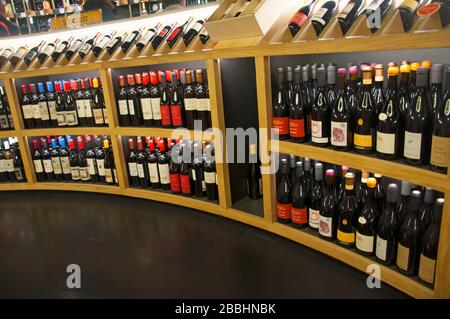 Rack demi-rond en bois avec différentes bouteilles de vin, musée du vin de Bordeaux, France Banque D'Images