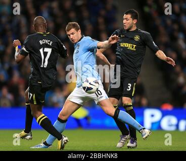 Wigan Athletic's Antolin Alcaraz (à droite) et Emmerson Boyce (à gauche) affrontent le ballon avec Edin Dzeko (au centre) de Manchester City. Banque D'Images