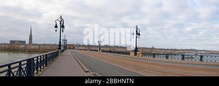 Vue panoramique sur le pont avec des rails de tramway, des lampes de rue et cityline. Nuageux hiver jour. Pont de Pierre, Bordeaux, France