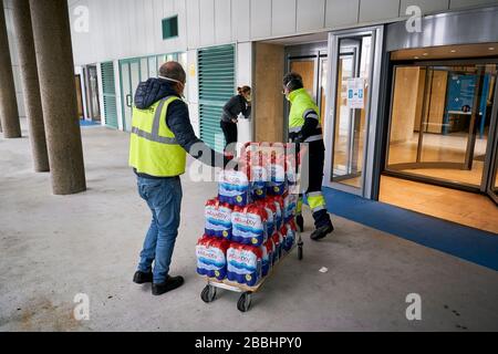 Les hommes de livraison déchargeant l'eau donnée.'Federacion de Penas' de Mostoles donne 4 000 l d'eau minérale à l'hôpital universitaire de Mostoles pour aider à lutter contre la pandémie du virus corona. Banque D'Images