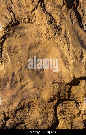 Graffiti avec des pétroglyphes sculptés par les peuples ancestraux de Pueblo qui occupaient autrefois Pueblo Bonito dans le parc historique national de la culture du Chaco, au Nouveau-Mexique Banque D'Images