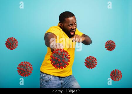 L'homme attaque avec un poinçon le covid 19 coronavirus. Fond bleu Banque D'Images